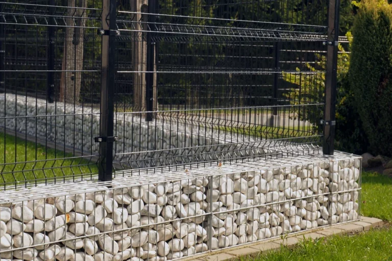 3D táblás kerítés fehér köves gabion alappal, modern kertben