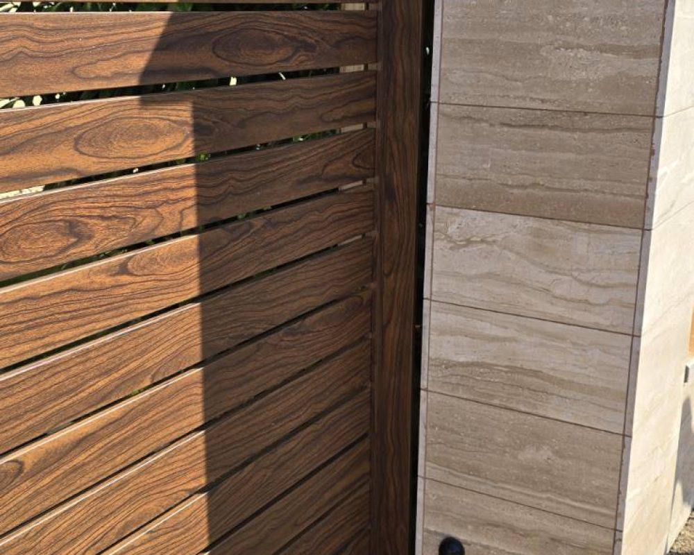 Faerezetes dió színű WPC kerítés kültéri környezetben, természetes fa hatású lécekkel